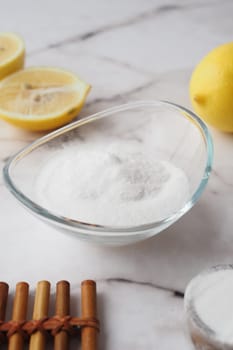 Baking soda and whole lemon on table .