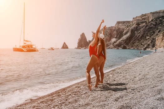 Side view a Young beautiful sensual woman in a mint long dress posing on a volcanic rock high above the sea during sunset. Girl on the nature on overcast sky background. Fashion photo