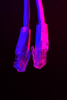 Modern technology network cable in neon light close up