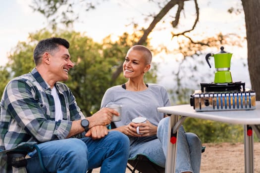 couple smiling happy while having coffee in the countryside, concept of active tourism in nature and outdoor activities