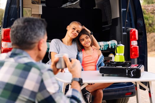 family camping in the countryside with their camper van, concept of active tourism in nature and outdoor activities with children