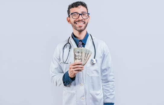 Happy young doctor holding money isolated. Handsome doctor showing money on white background