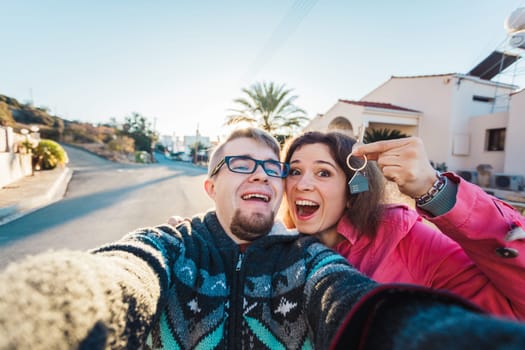 real estate: couple showing keys of their new house