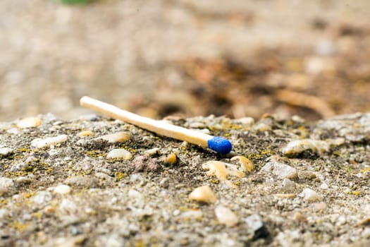 A match, a hand with matches against the background of old garages in city.