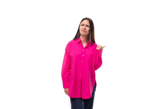 pretty young brunette lady dressed in a bright pink shirt points with her hands in a row of advertising.