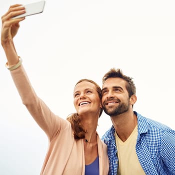 Couple, phone and selfie on holiday, smile and outdoors on adventure, love and memories for social media. Happy people, smartphone and bonding or technology, travel and vacation or profile picture.