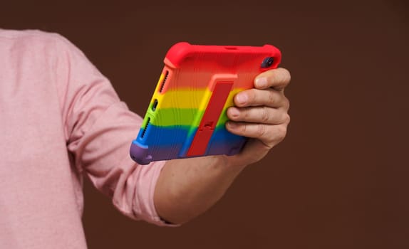 Sign of gay culture and LGBTQ pride representing man's hand holding pocket PC adorned in rainbow colors, Rainbow symbolism reflects diversity and inclusivity of LGBTQ community. High quality photo