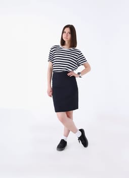 Fashion model of a woman in a striped T-shirt and skirt on a gray background in full growth