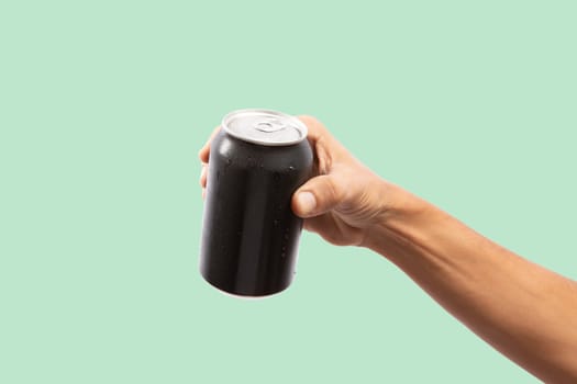 Close-up of hand holding Empty aluminum can with condensation. isolated on green Background. front view.