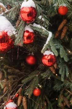 Christmas trees decorated with red balloons in front of the cafe entrance. Street Christmas decorations