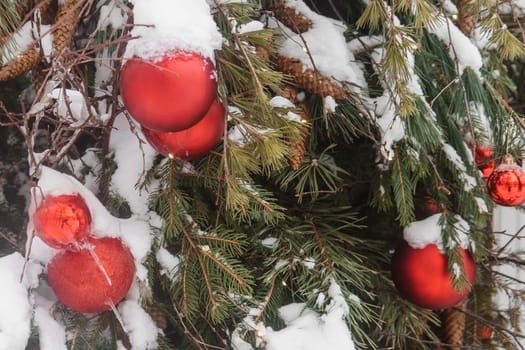 Christmas trees decorated with red balloons in front of the cafe entrance. Street Christmas decorations