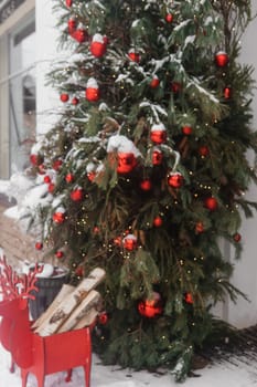 Christmas trees decorated with red balloons in front of the entrance to the cafe. Street Christmas decorations