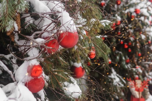 Christmas trees decorated with red balloons in front of the entrance to the cafe. Street Christmas decorations