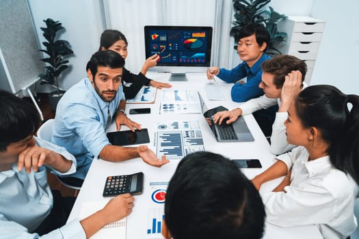 Analyst team utilizing BI Fintech to analyze financial data at table in meeting room. Businesspeople analyzing BI dashboard power for business insight and strategic marketing planning. Prudent