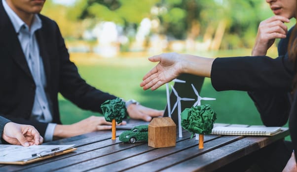 Group of asian business people presenting environmentally friendly development plan and sustainable technology project for greener future, establishing outdoor eco business office at natural park.Gyre