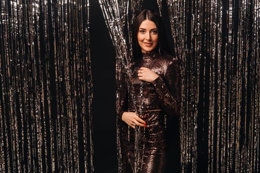 girl in a shiny dress on a silver background of New Year's rain.