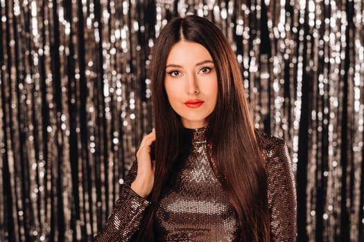 a girl in a shiny jacket on a silver background of New Year's rain.