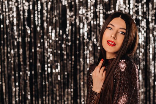 a girl in a shiny jacket on a silver background of New Year's rain.