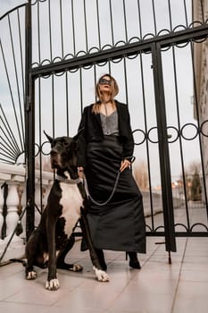 A woman walks with her Great Dane in an urban setting, enjoying the outdoors and the company of her dog