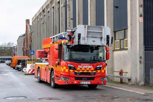 Copenhagen, Denmark - November 10, 2023: Side view of a fire truck parked on a street in an industrial area.