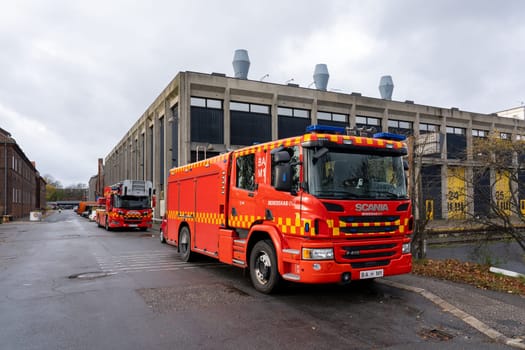 Copenhagen, Denmark - November 10, 2023: Side view of a fire truck parked on a street in an industrial area.