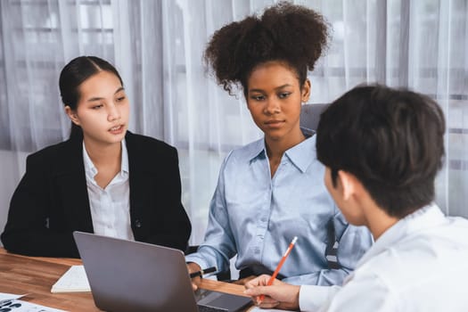 Happy diverse business people work together, discussing in corporate office. Professional and diversity teamwork discuss business plan on desk with laptop. Modern multicultural office worker. Concord