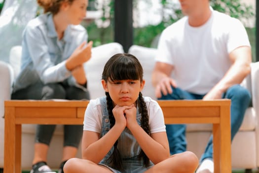 Stressed and unhappy young girl crying and trapped in middle of tension by her parent argument in living room. Unhealthy domestic lifestyle and traumatic childhood develop to depression. Synchronos