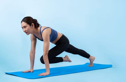 Asian woman in sportswear doing burpee on exercising mat as workout training routine. Attractive girl in pursuit of healthy lifestyle and fit body physique. Studio shot isolated background. Vigorous