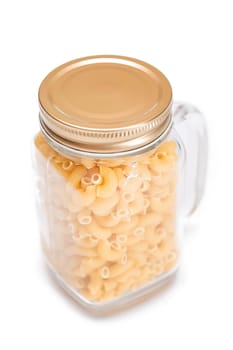 Uncooked Chifferi Rigati Pasta in Glass Jar Isolated on White Background. Fat and Unhealthy Food. Classic Dry Macaroni. Italian Culture and Cuisine. Raw Pasta - Isolation