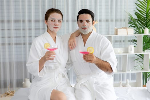 Serene modern daylight ambiance of spa salon, couple customer indulges in rejuvenating with facial skincare mask. Facial skin treatment and beauty cosmetology procedure for face. Quiescent