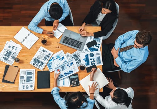 Panorama top view diverse group of business analyst team analyzing financial data report paper on meeting table. Chart and graph dashboard by business intelligence analysis. Meticulous