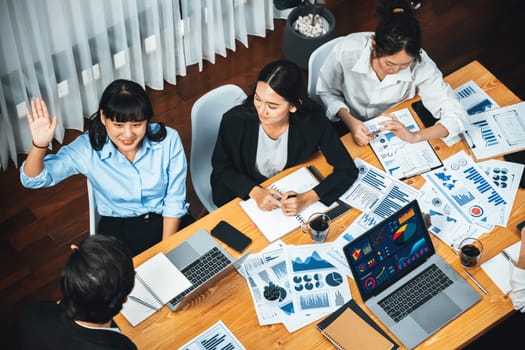 Diverse ethnic group of analyst team actively engage in business meeting, demonstrate their expertise by raise hand, asking insightful questions with TV screen show data analysis dashboard. Meticulous