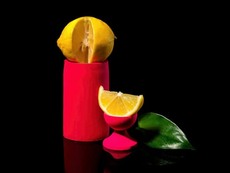 Creative still life Composition with lemon and a slice of lemon on a stand on a black background