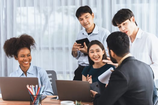 Happy diverse business people work together, discussing in corporate office. Professional and diversity teamwork discuss business plan on desk with laptop. Modern multicultural office worker. Concord