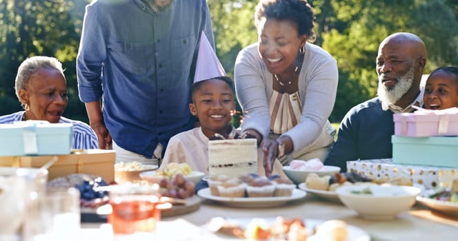 Young boy, birthday cake or family in garden for party, happy or gift in celebration in nature. Black people, smile and cream dessert with fun with bonding, excited and special kid event in backyard.
