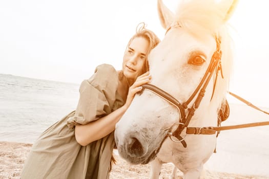 A woman in a dress stands next to a white horse on a beach, with the blue sky and sea in the background