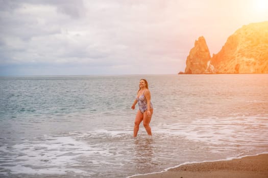 A plump woman in a bathing suit enters the water during the surf. Alone on the beach, Gray sky in the clouds, swimming in winter