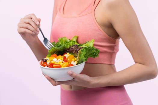 Young sporty Asian woman in sportswear holding salad bowl fill with vibrant of fruit and vegetable. Natural youthful and fit body lifestyle with balance nutrition on isolated background. Vigorous