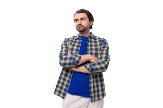 smart brunette macho man with a beard and mustache in a blue shirt on a white background with copy space.