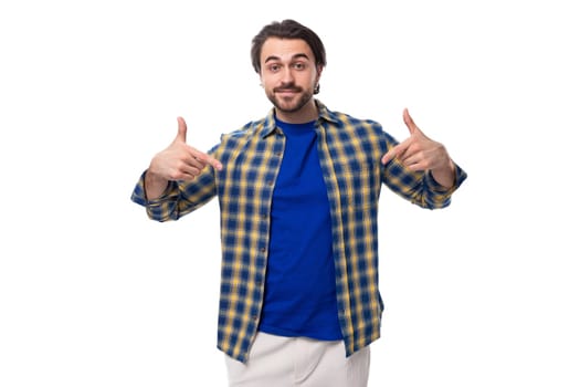 smart brunette macho man with a beard and mustache in a blue shirt on a white background with copy space.