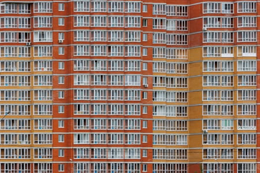 large cheap russian new apartment building wall with enormous quantity of windows, full-frame background and texture