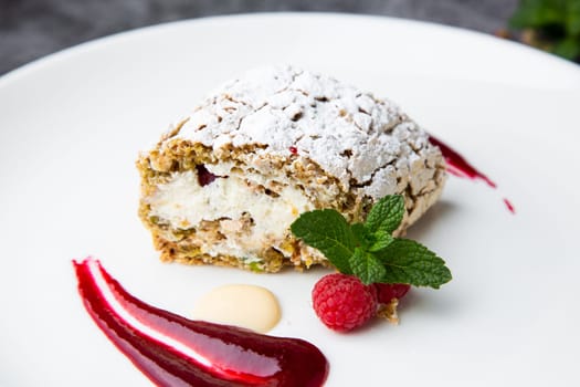 sweet sponge dessert with raspberries and powdered sugar