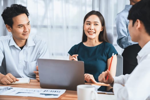 Multiracial analyst team use BI dashboard data to analyze financial report on meeting table. Group of diverse business people utilize data analysis by FIntech for success business marketing. Concord