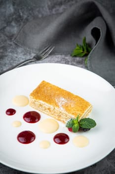 white sponge cake with drops of syrup, mint and wild berries