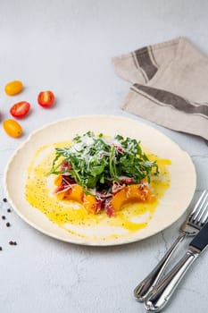 green salad with arugula and lingonberries on a white plate and marble background