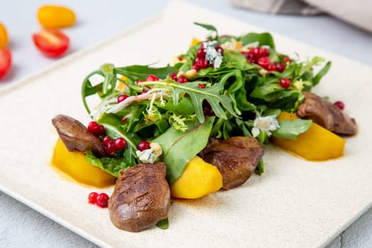 meat medallions with arugula, peach slices and red berries