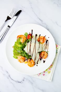 shrimp with avocado slices and arugula with teriyaki sauce