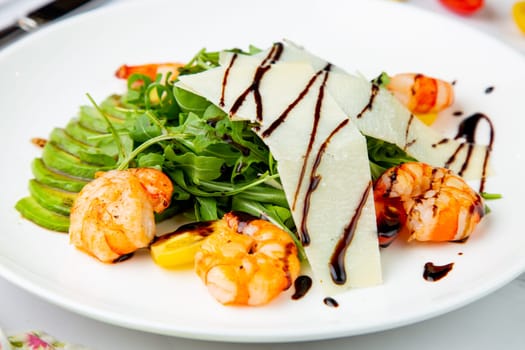 shrimp with avocado slices and arugula with teriyaki sauce