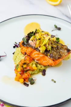 red fish with vegetable sauce and puree on a round plate