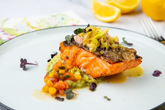 red fish with vegetable sauce and puree on a round plate